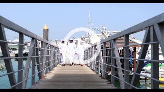 Three arab men walking on the dock talking to each other|