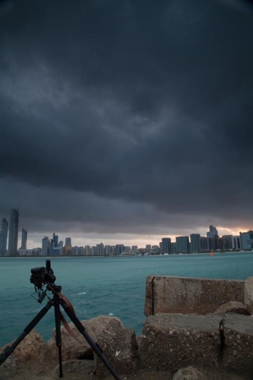 camera on rocks and city view