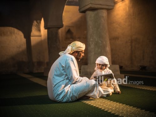 Boy praying with grandfather at the mosque|-