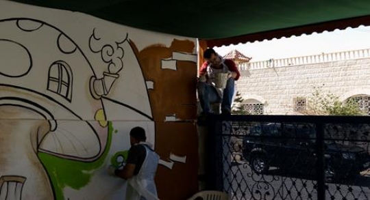 group of volunteer painting the wall of kindergarten