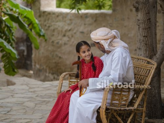 Happy girl sitting with grandfather|-