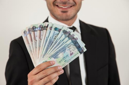 man hands holding uae currency note