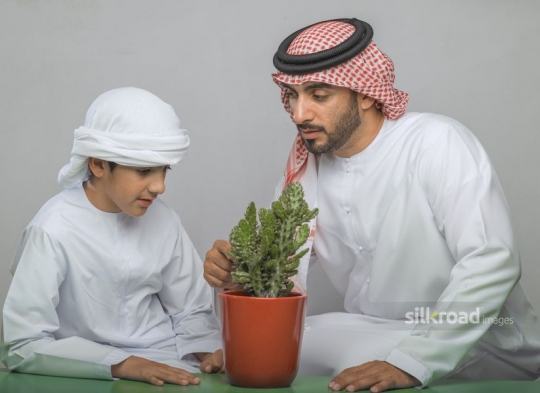 father observing a plant with his son