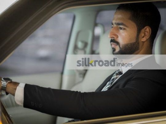 Middle Eastern Businessman sitting inside the car|