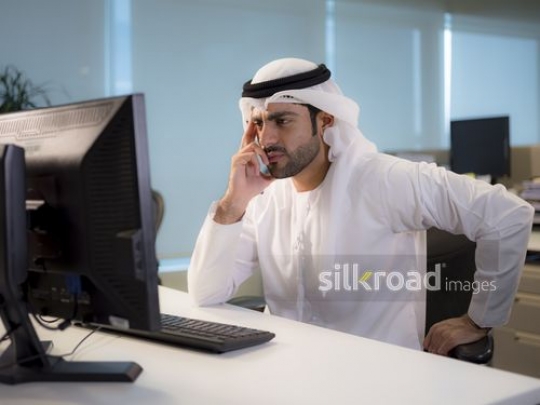 Business man sitting by his desk and thinking while looking at the computer|