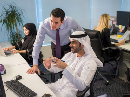 Business men at the office talking to each other about work|