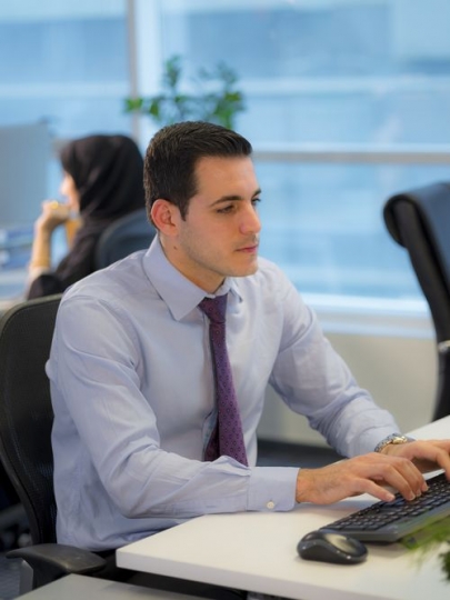 Employee is sitting by the desk doing work|-