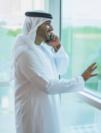 Businessman looking outside the window while making a phone call|-