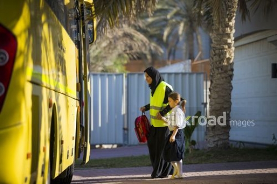 Young student walking with the supervisor to the school bus|-