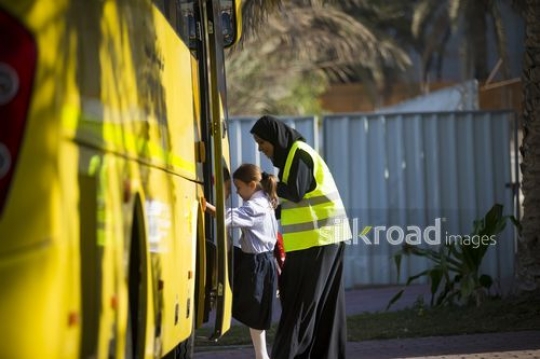Supervisor helping the Western Student get on the bus|-