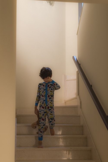 Boy walking down the stairs in the morning|-