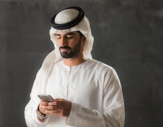 Portrait of an arab man on his phone|-