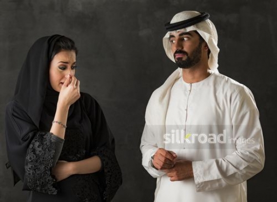 Middle Eastern man looking at the Middle Eastern woman crying|