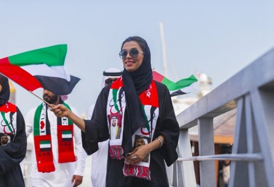 Arab woman during a National Day Parade by the dock|