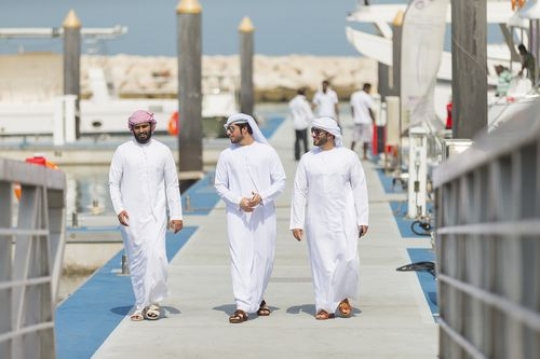 Three friends walking towards the dock and communicating with each other|
