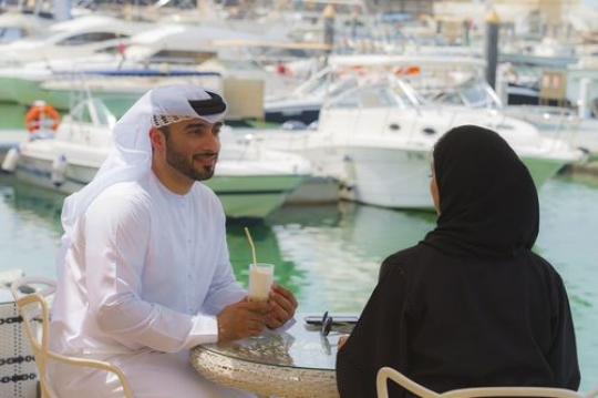 Arab friends sitting outside and talking to each other|