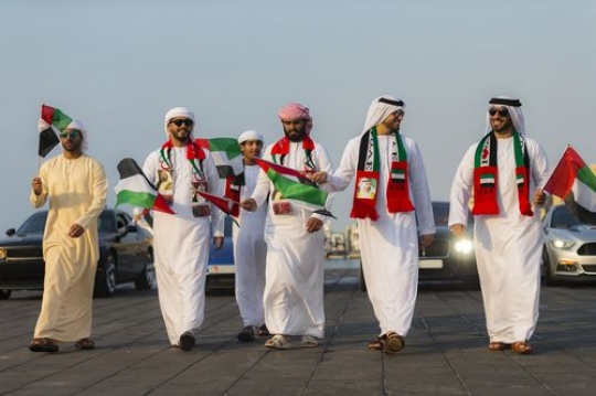 Emirati men followed by luxurious cars during the UAE National Day Parade|-