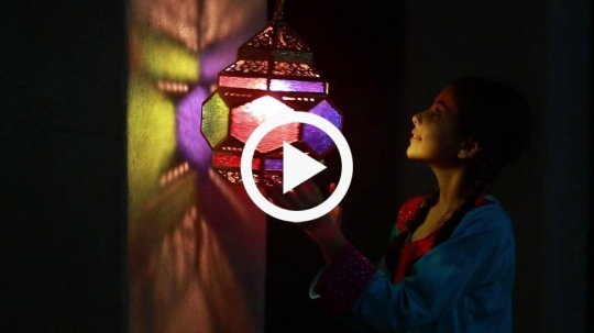 Girl rotating the lantern against the wall