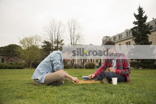 Two men sitting together playing a game|
