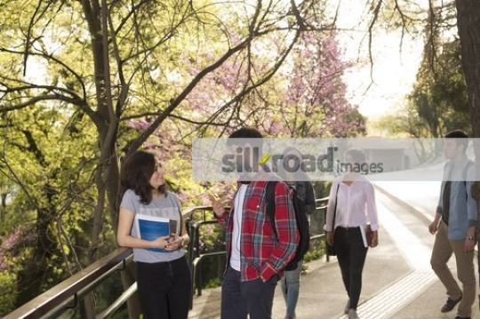 Two students standing together talking|