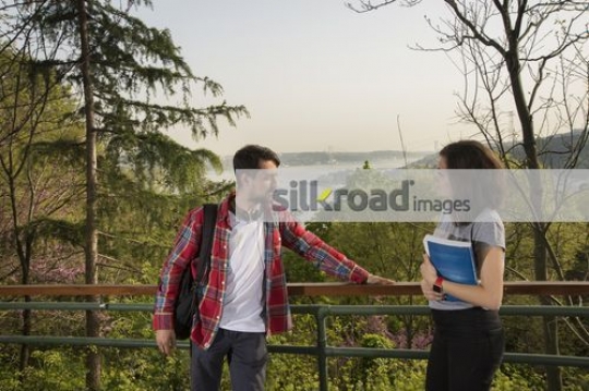 Two students standing together talking|