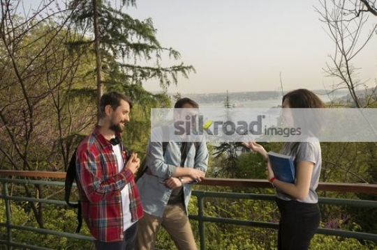 Friends standing on the bridge talking|