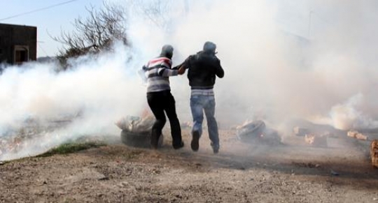 palestinians seek cover from tear gas during clashes
