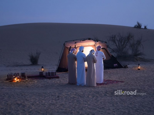 Middle Eastern men praying at the desert