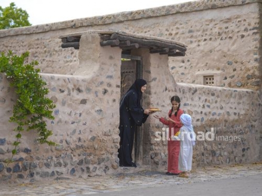 Woman receiving kids at the door|-