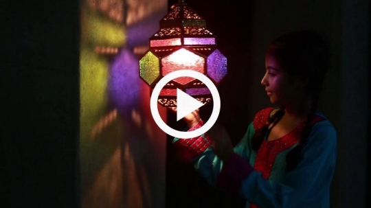 Girl rotating lantern against the wall