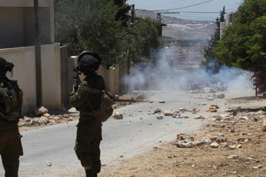 israeli soldier fires tear gas