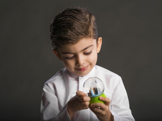 Little boy observing snowball