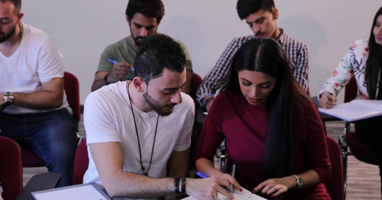 Students helping each other in class|-