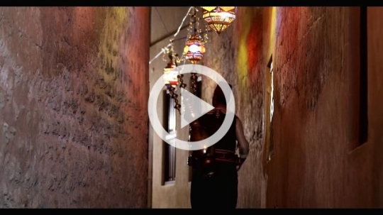 Arabian Ramdan Drink Seller walking through the alleyway decorated by Ramadan Lanterns|
