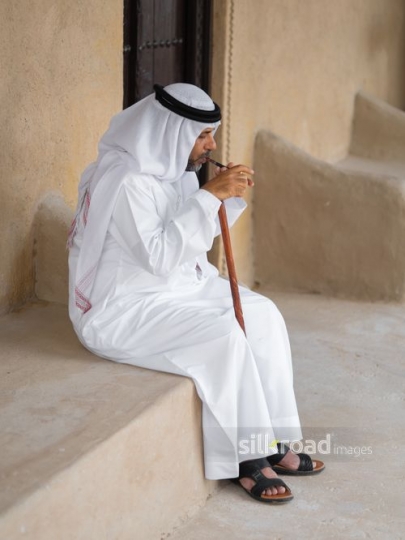 Old man smoking pipe outside|-