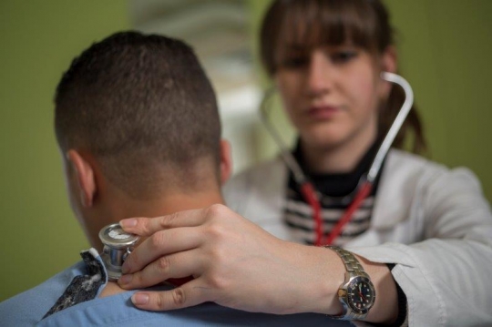 A Woman Doctor Examining Patient at Hospital