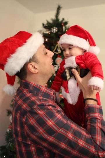 Newborn baby with Santa Hat, held by his father