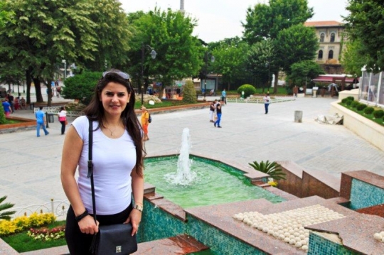 woman in green park with fountain