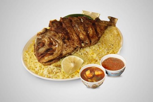 A plate of traditional Gulf Arab fish majboos (baked fish with special rice, cooked with saffron, onion, tomato, cardamom, raisins etc), a favourite delicacy on the Gulf coast. 
