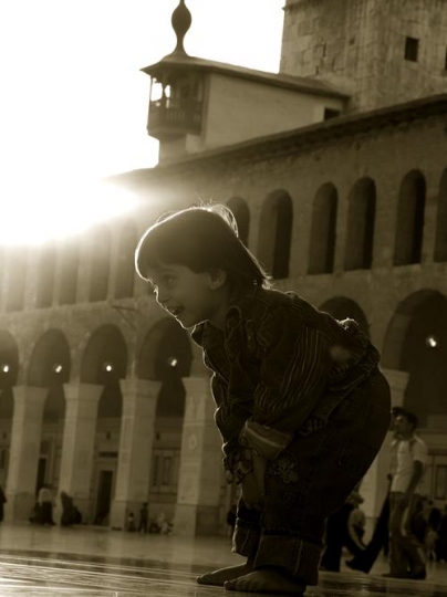 kid in a mosque yard preying