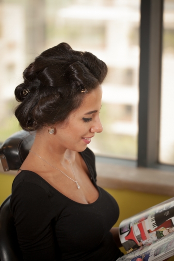 Woman sitting down reading a magazine at the hair salon|