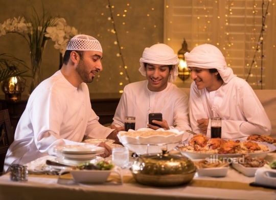 Man with boys checking mobile phone|-