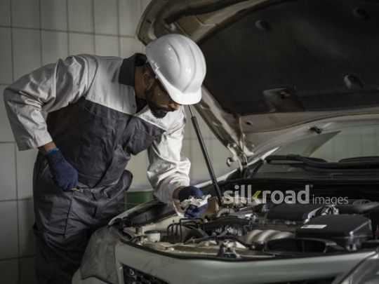Mechanic Worker checking the oil of the car|-