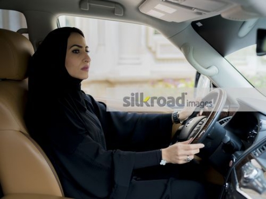 Arab Businesswoman dressed in the traditional attire sitting in the car|