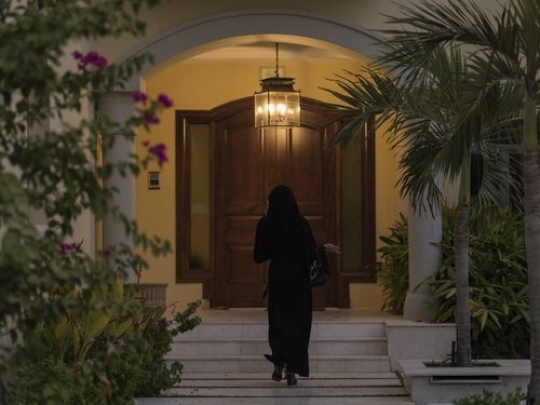 Arab woman walking towards the house|-