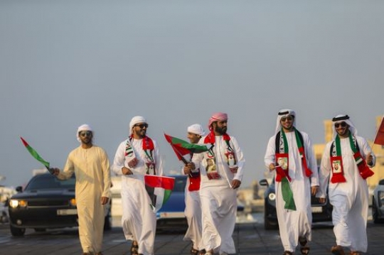 Emirati men followed by luxury cars celebrating the UAE National Day|-