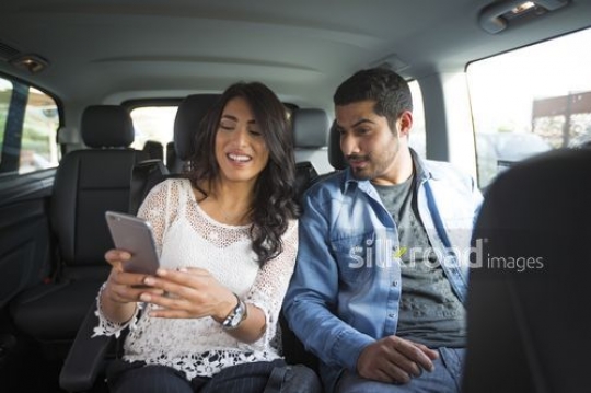 Man and woman both looking at the mobile|-