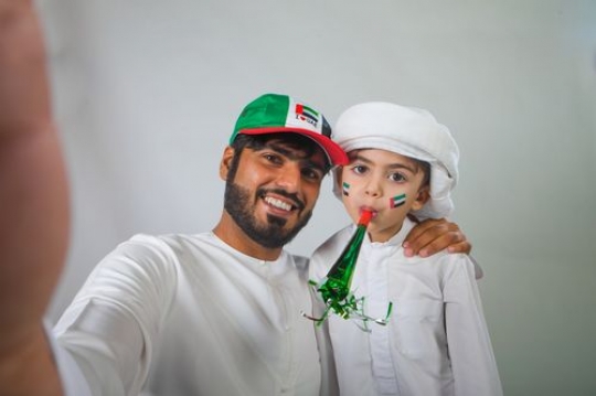 Arab Father and Son taking a Selfie for National Day