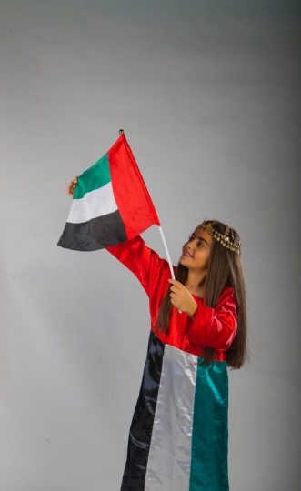 Emirati Girl carrying the UAE Flag