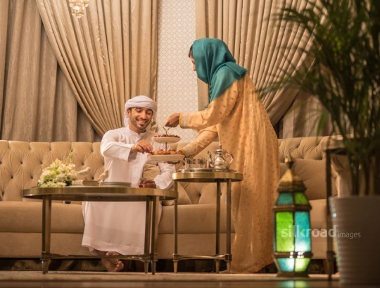 Wife serving husband Arabic sweets |-